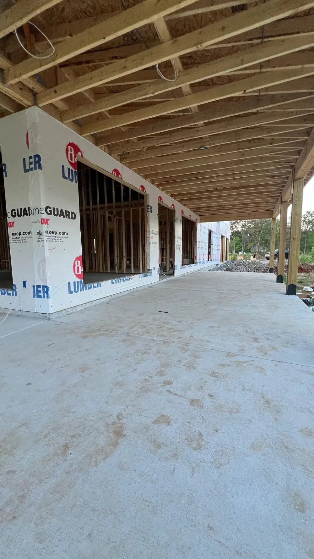 A long covered porch framed in timber on a new concrete slab